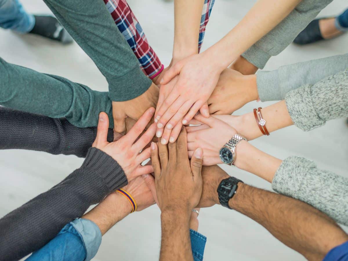 an overhead view of many hands together